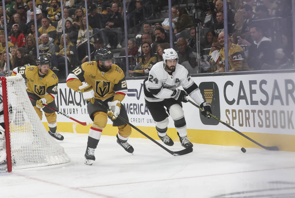 Los Angeles Kings center Phillip Danault (24) skates with the puck under pressure from Golden K ...