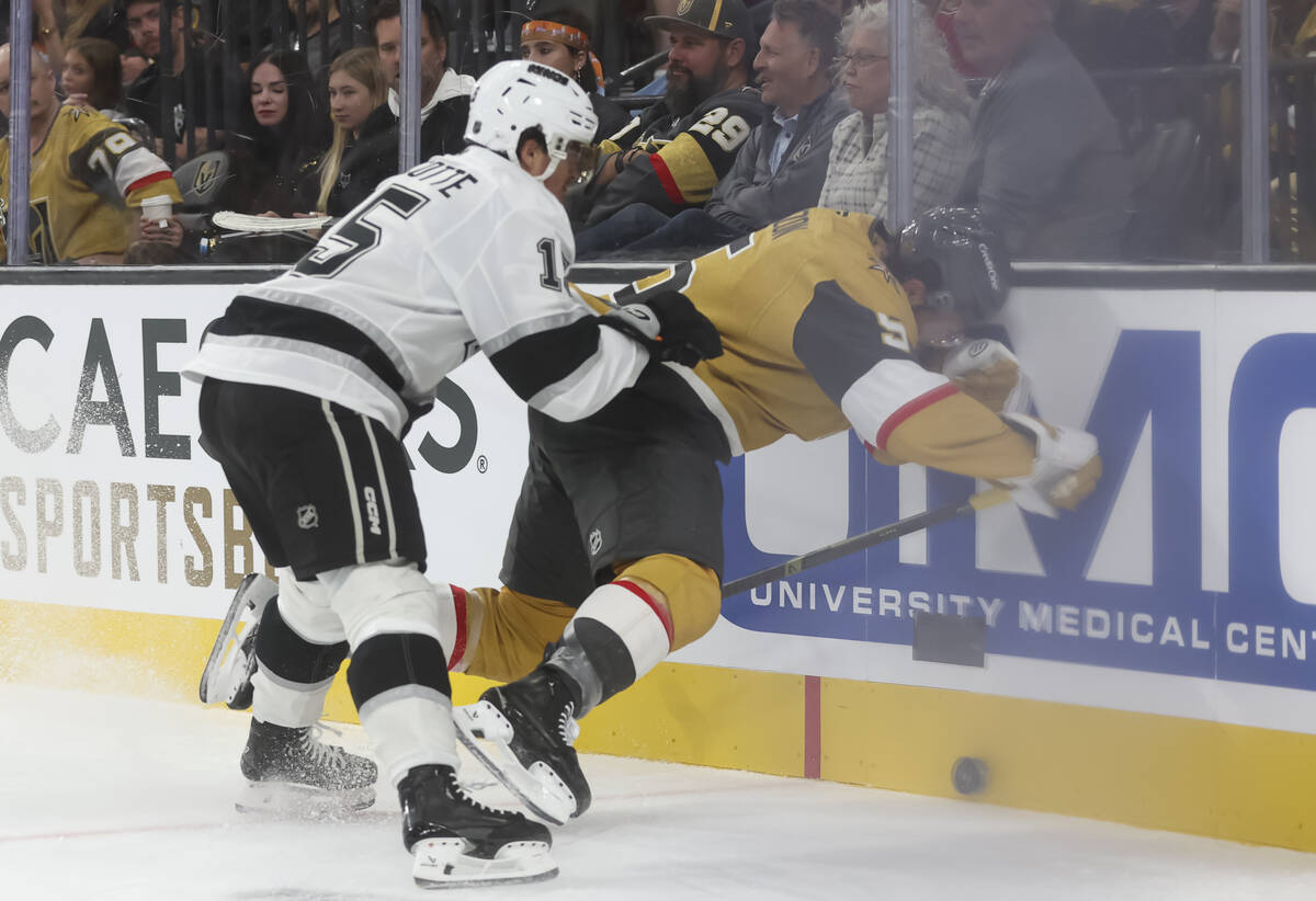 Los Angeles Kings center Alex Turcotte (15) pushes Golden Knights defenseman Jeremy Lauzon (5) ...