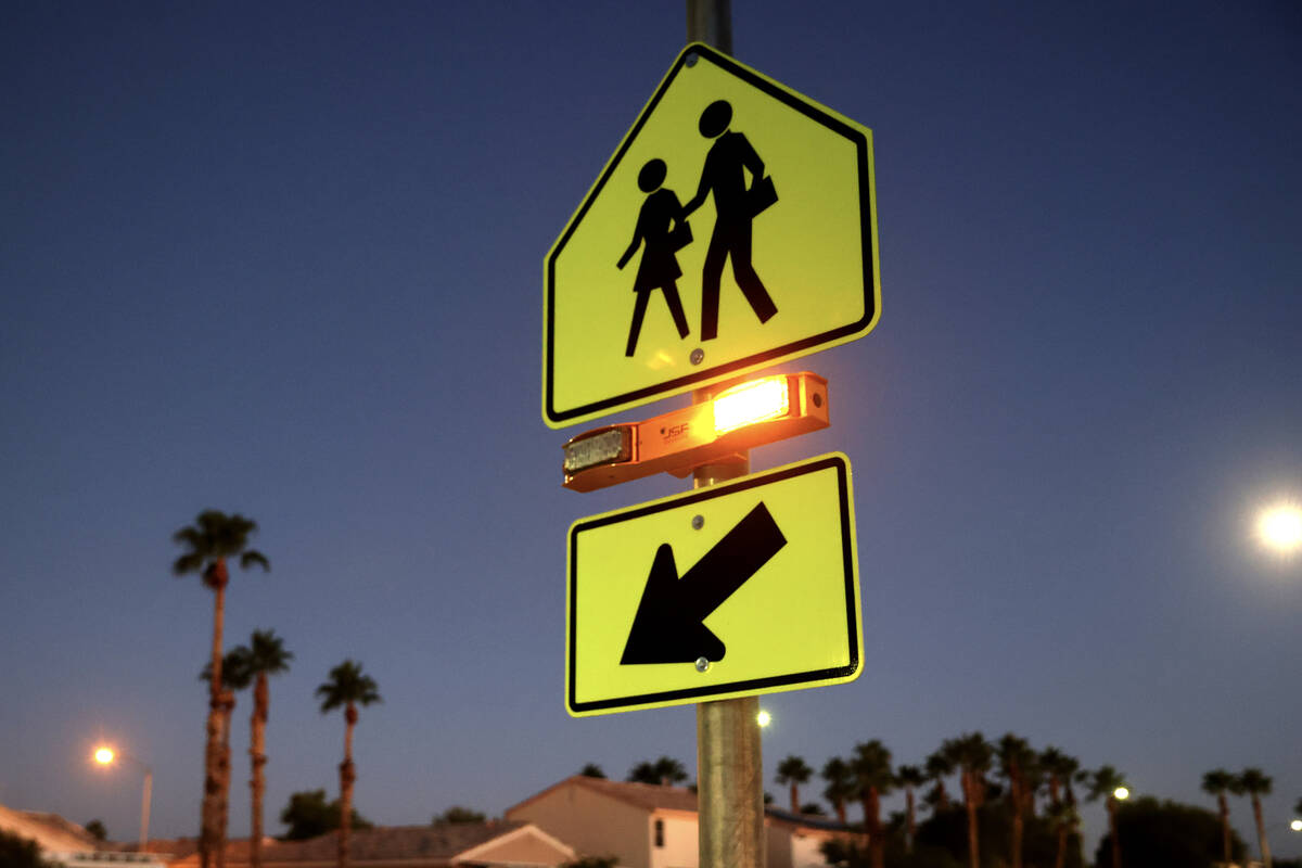 A school crossing sign with flashing lights is seen at Arbor View High School in Las Vegas Wedn ...