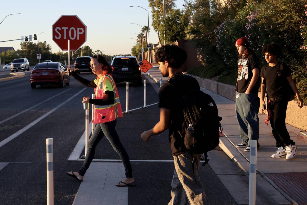 Bethany Limov, a volunteer with Walk Safely LV, helps students get across North Buffalo Drive a ...
