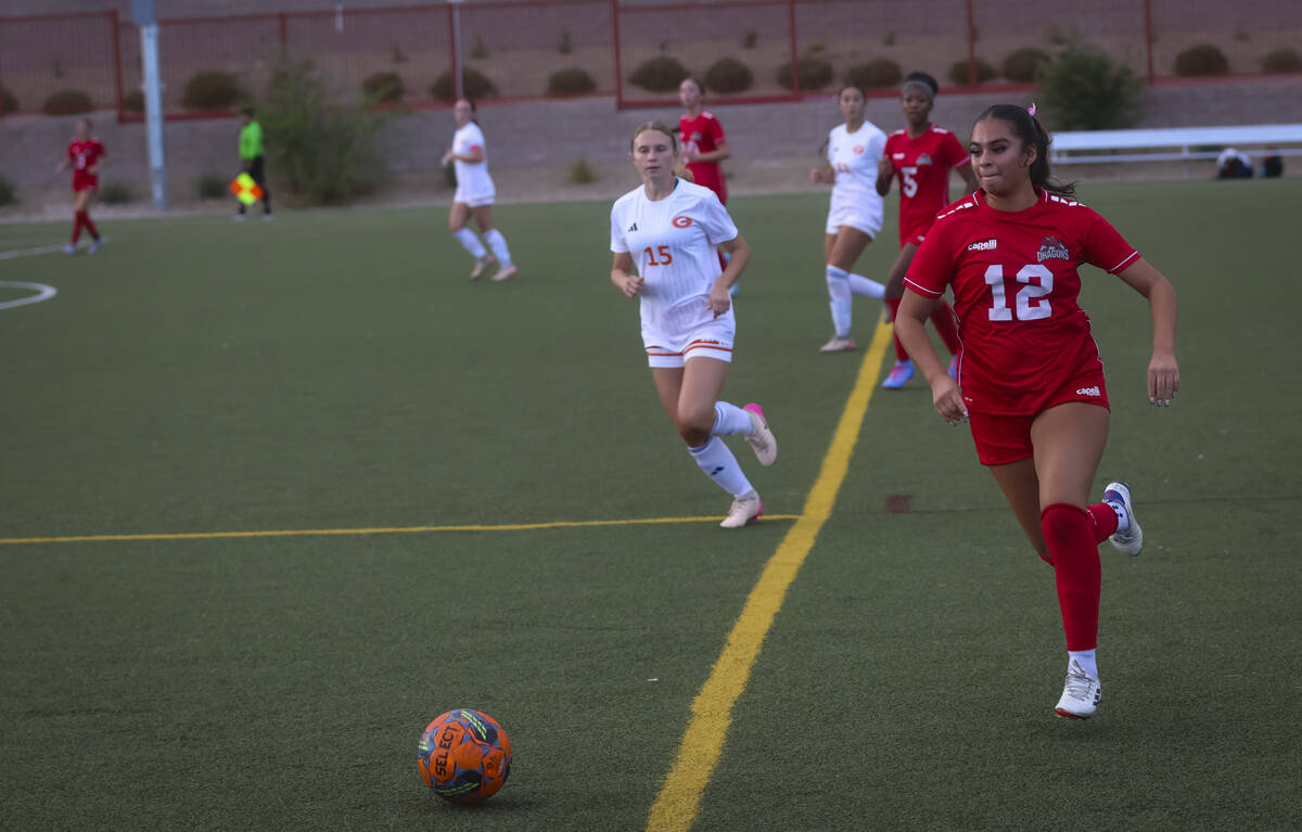 Doral Academy's Dasha Rosas (12) runs with the ball as Bishop Gorman's Elsa McPeak (1 ...