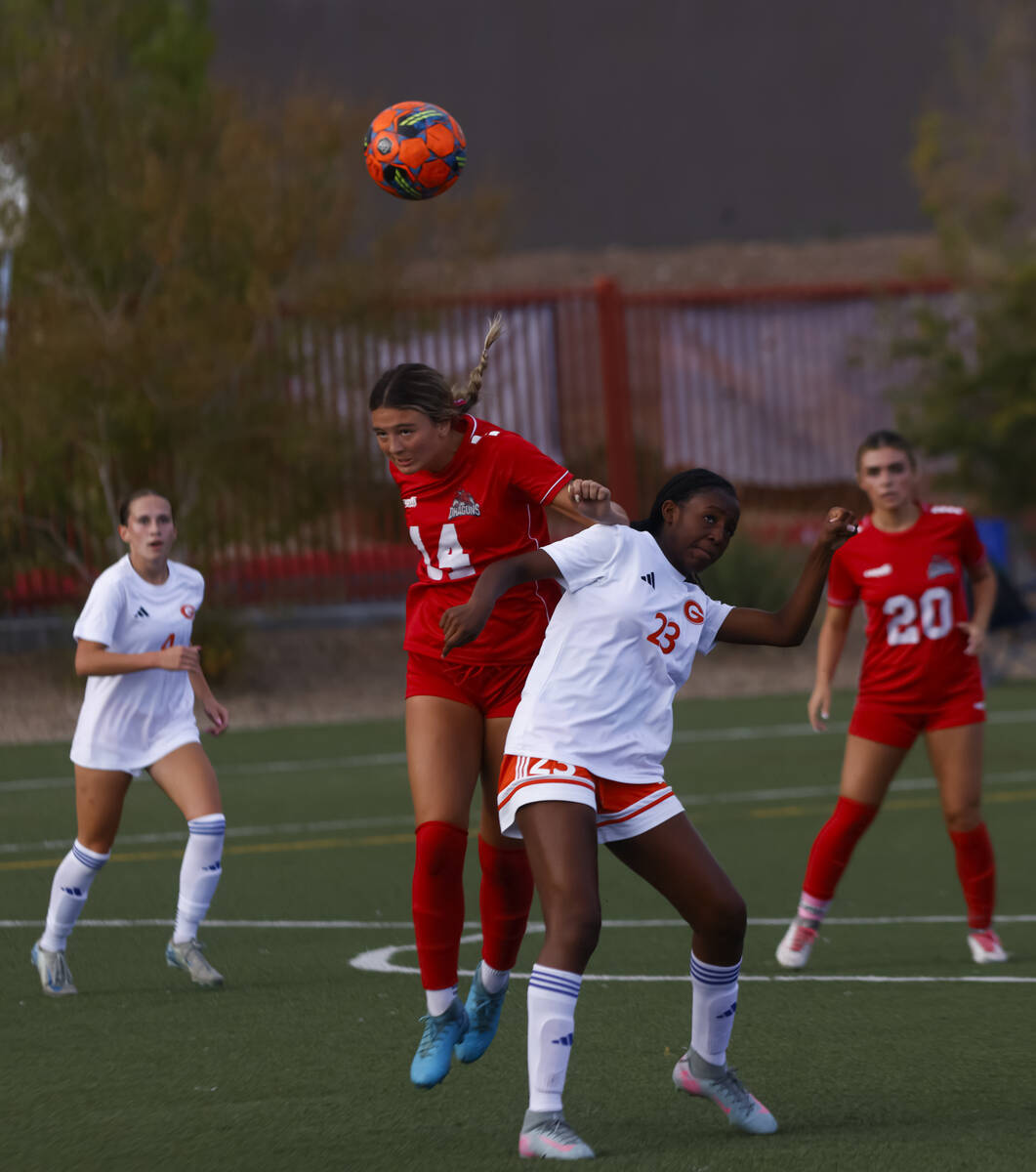 Doral Academy's Peyton Hedstrom (14) heads the ball over Bishop Gorman's Aleah Warner ...