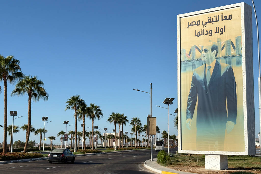 A vehicle passes in front of a billboard showing Egyptian President Abdel Fattah el-Sissi at th ...