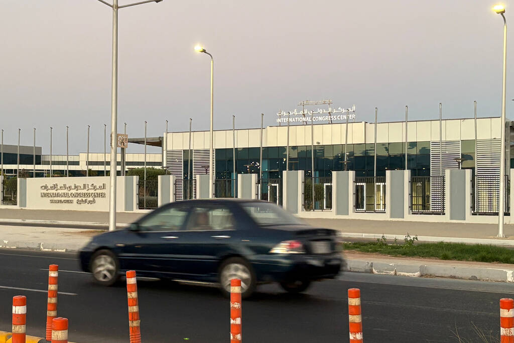 A vehicle passes in front of the International Conference Center where Israeli and Hamas offici ...