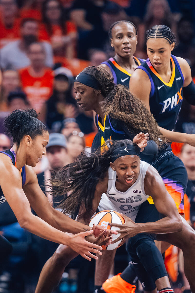 Aces guard Jackie Young (0) tries to keep hold of the ball against Phoenix Mercury defense duri ...
