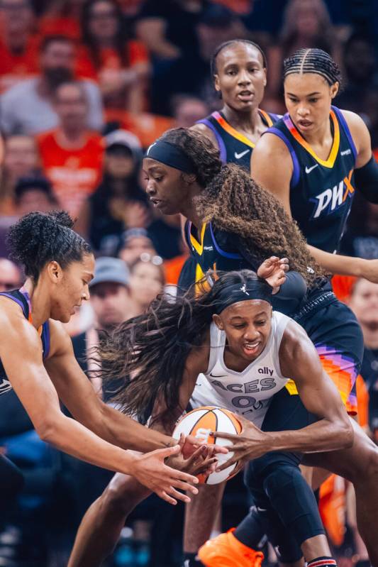 Aces guard Jackie Young (0) tries to keep hold of the ball against Phoenix Mercury defense duri ...