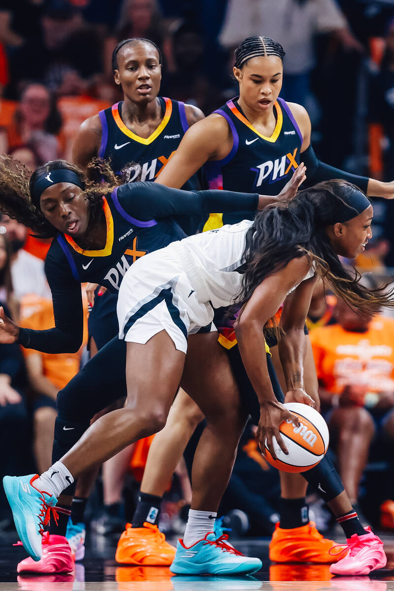 Aces guard Jackie Young (0) tries to keep hold of the ball against Phoenix Mercury defense duri ...