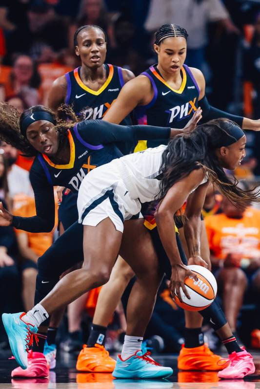 Aces guard Jackie Young (0) tries to keep hold of the ball against Phoenix Mercury defense duri ...
