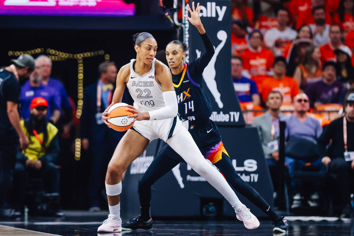 Aces center A'ja Wilson (22) schemes her next move as Phoenix Mercury forward DeWanna Bonn ...