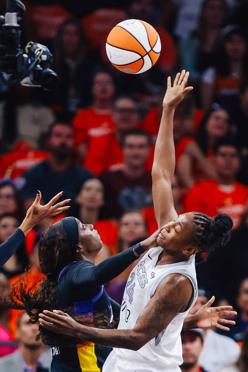 Aces guard Jewell Loyd (24) takes a hand to the face from Phoenix Mercury guard Kahleah Copper ...