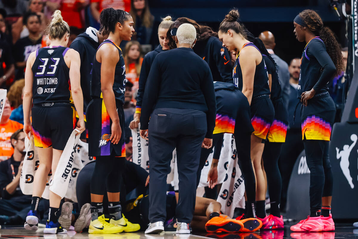 Phoenix Mercury players surround Phoenix Mercury forward Satou Sabally as she suffers from an i ...