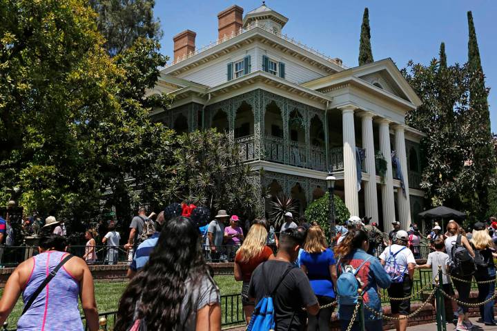 Guests wait in line at the Haunted Mansion at Disneyland in Anaheim, California, on June 30, 20 ...