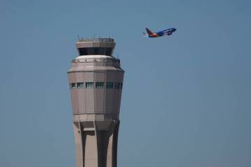 A plane takes off near the air traffic control tower at Harry Reid International Airport, Tuesd ...