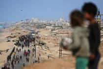 Displaced Palestinians gather on the coastal road near Wadi Gaza after the announcement that Is ...