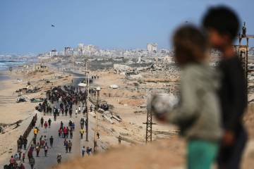 Displaced Palestinians gather on the coastal road near Wadi Gaza after the announcement that Is ...