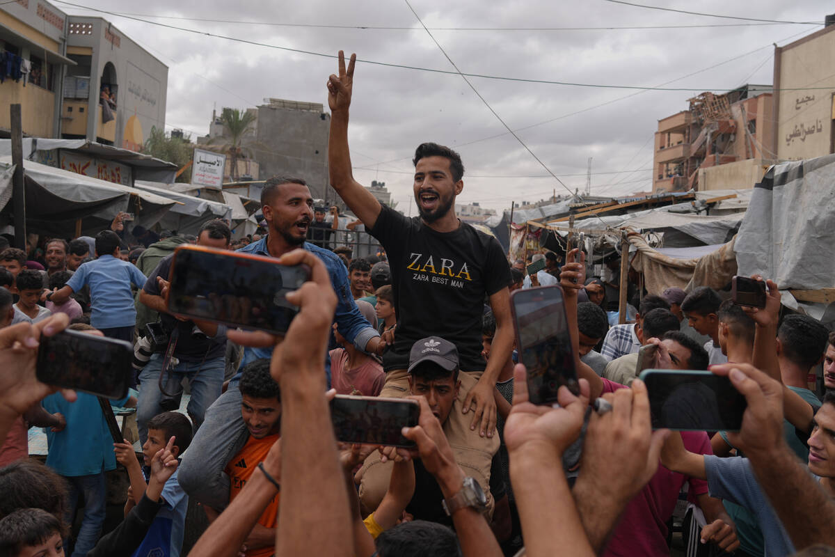 Palestinians celebrate following the announcement that Israel and Hamas have agreed to the firs ...