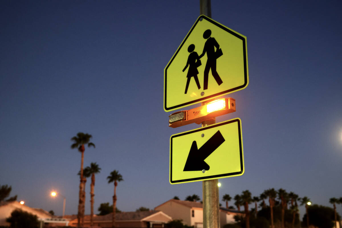 A school crossing sign with flashing lights is seen at Arbor View High School in Las Vegas Wedn ...