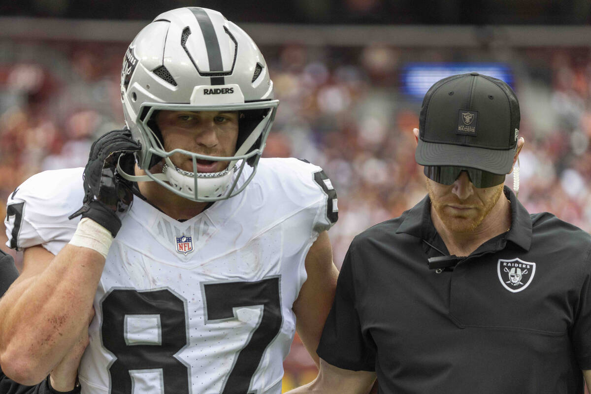 Raiders tight end Michael Mayer (87) comes off of the field with the help of a trainer after su ...