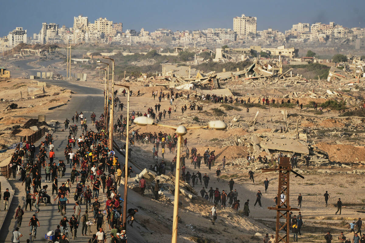 Israeli tanks are positioned on the coastal road leading to Gaza City as displaced Palestinians ...