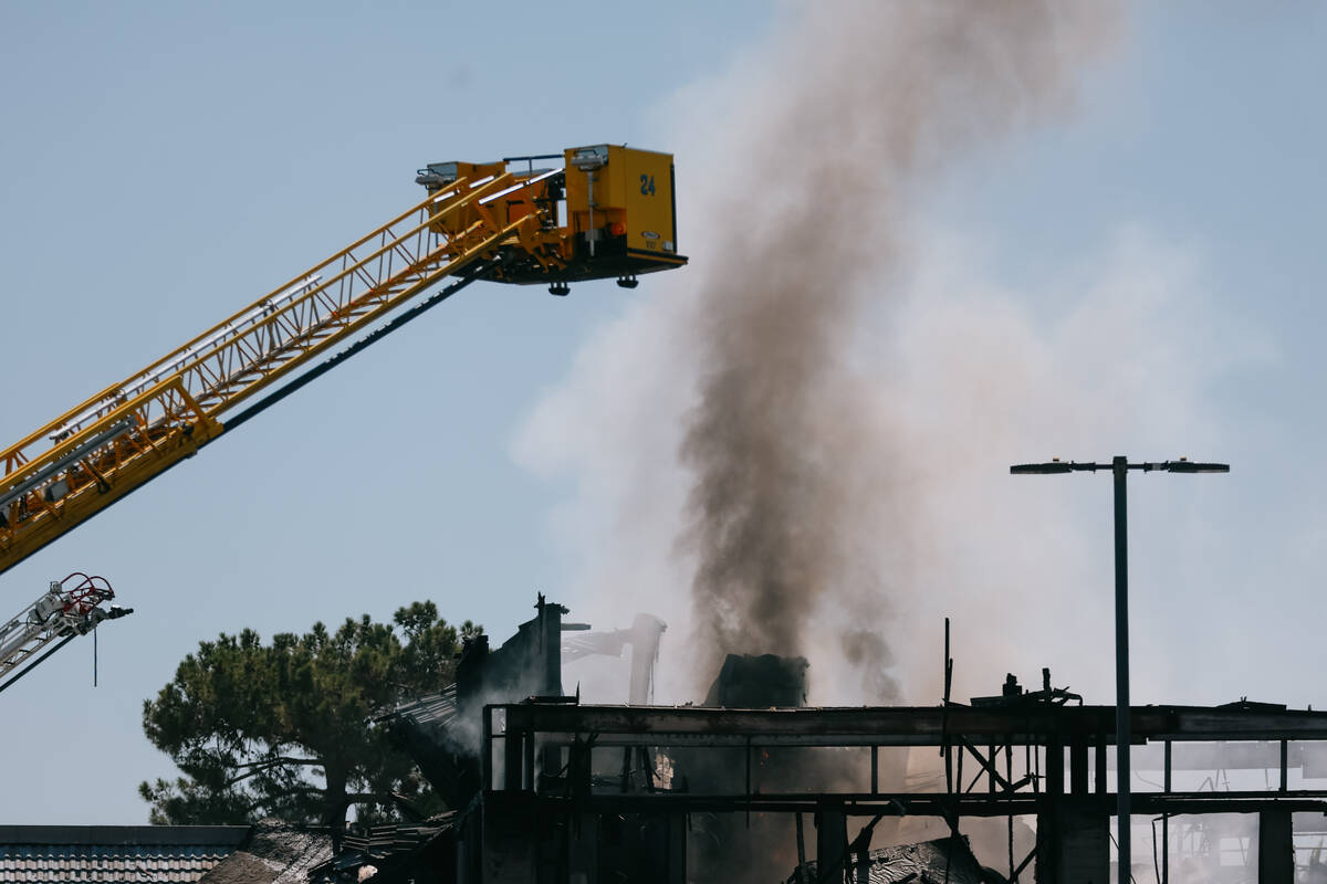 Firefighters douse the still-smoking building that once housed the post office on Maryland Park ...