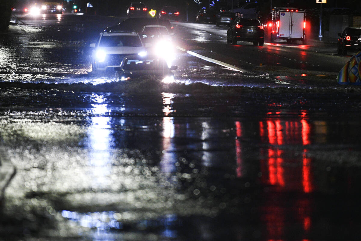 Cars travel through flood water on McLeod Drive near Desert Inn Road Friday, October 10, 2025, ...
