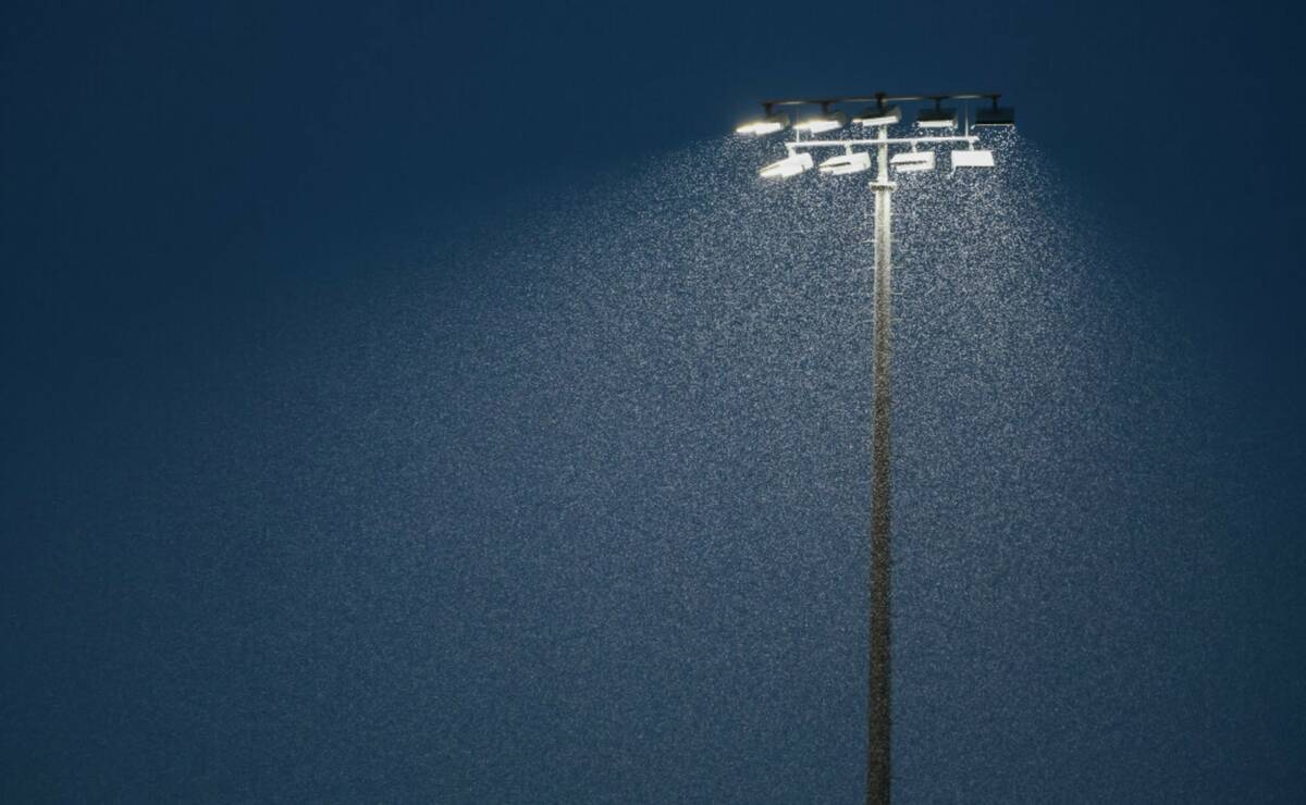 Rain pours down under the stadium lights, where a football game between Desert Pines and Las Ve ...