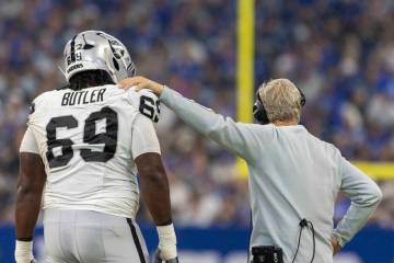 Raiders head coach Pete Carroll meets with Raiders defensive tackle Adam Butler (69) during a t ...