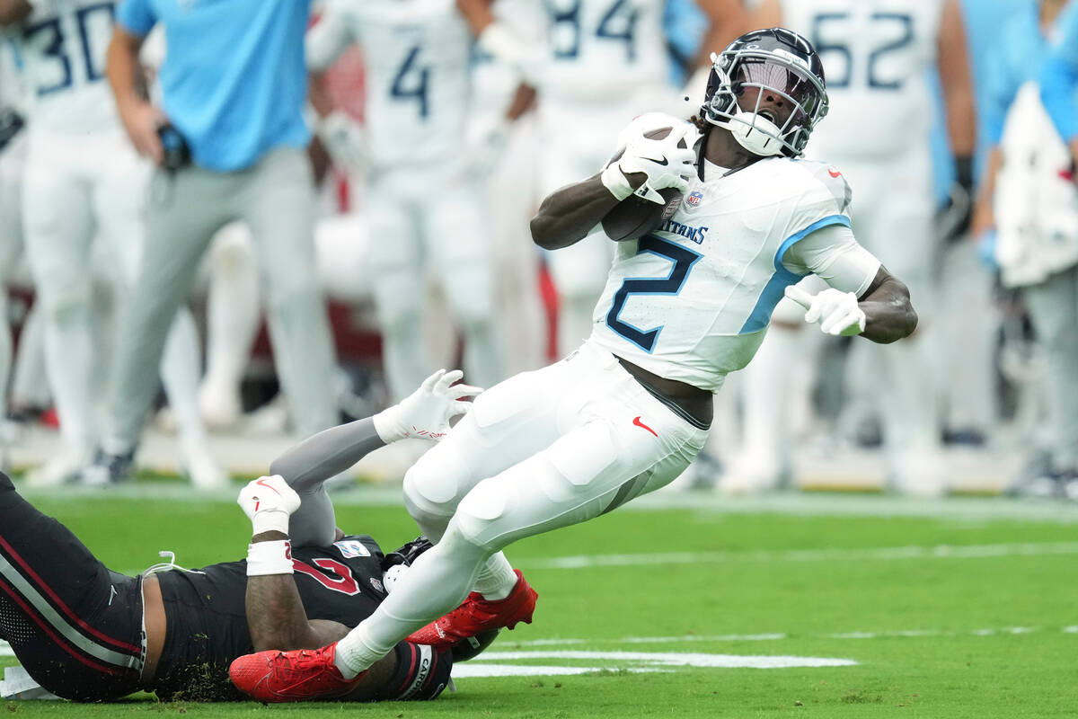 Tennessee Titans running back Tyjae Spears (2), right, runs the ball past Arizona Cardinals lin ...