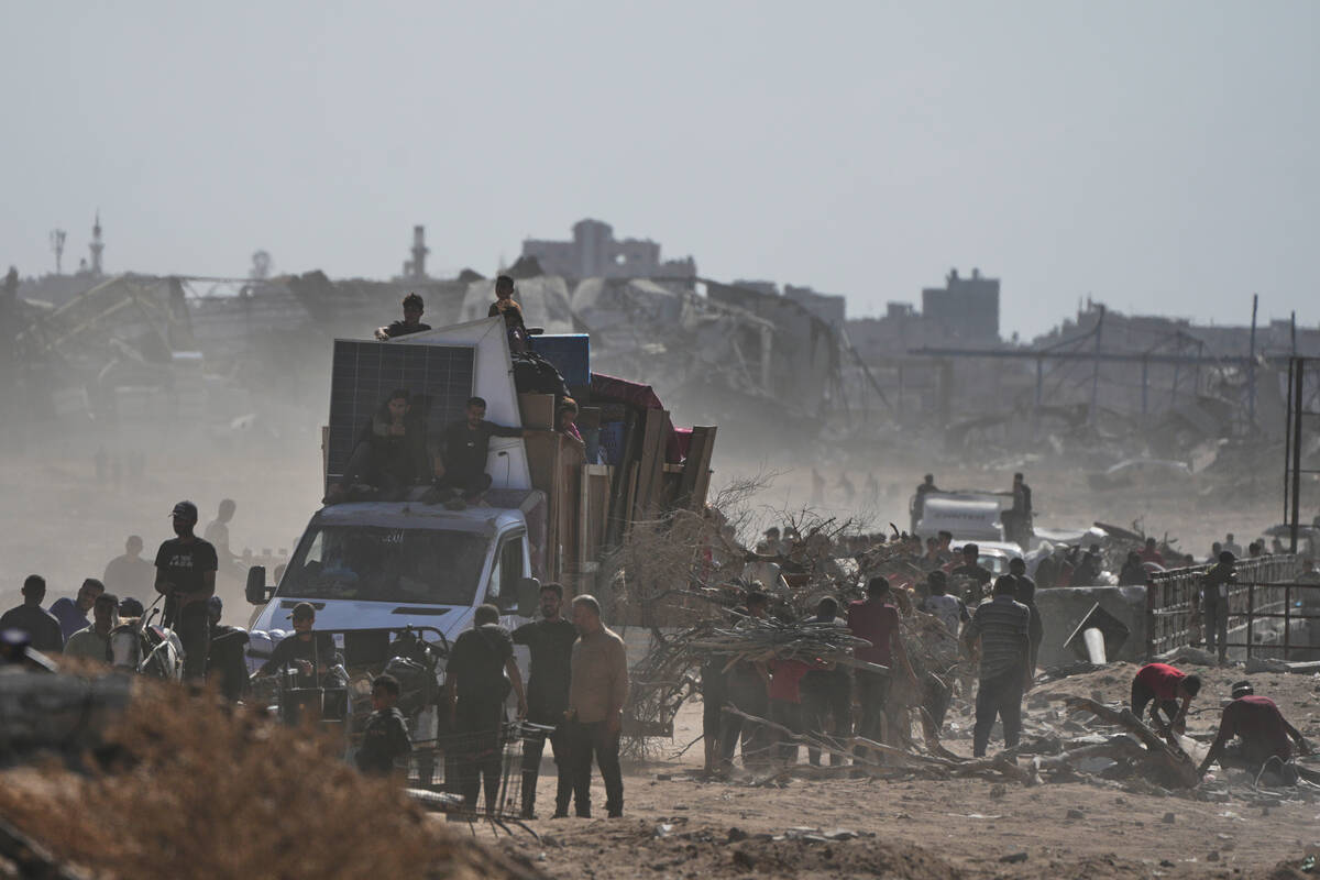 Displaced Palestinians load their belongings onto trucks as they return to Gaza City, in the no ...