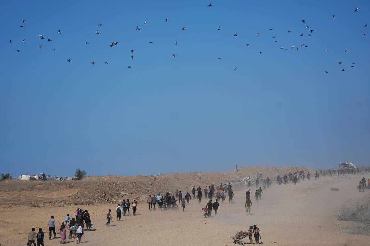 Displaced Palestinians walk toward Gaza City, in the northern Gaza Strip, Friday, Oct. 10, 2025 ...