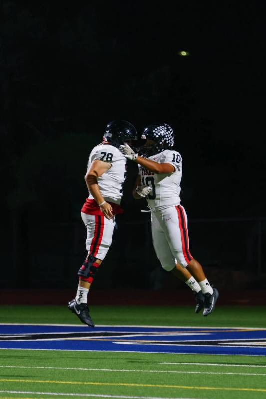 Las Vegas High School’s Ky Brinkerhoff (78) and Chris Fernandez (10) hype each other up ...