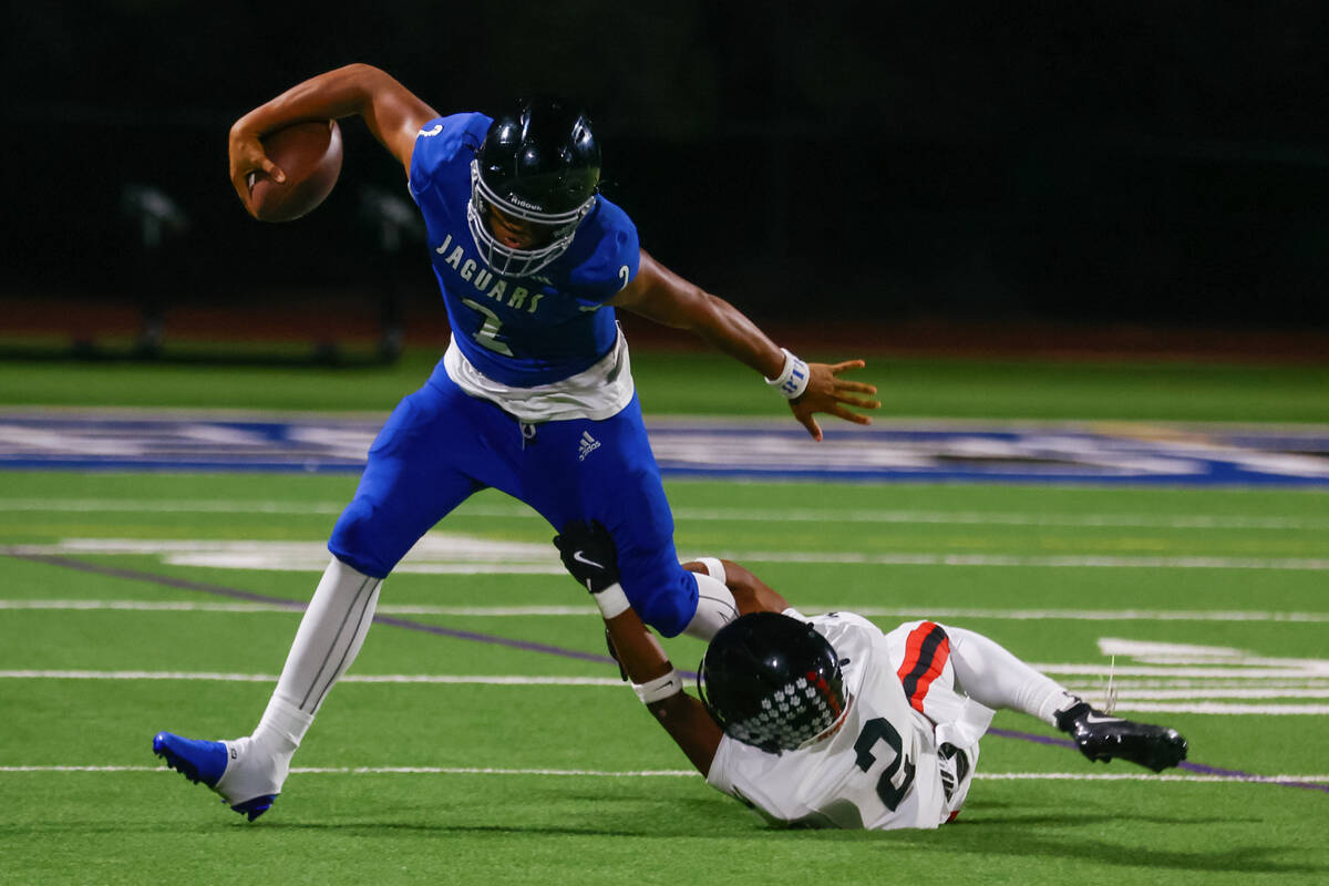 Las Vegas safety Aiden Weigum (2) trips up Desert Pines quarterback Jerome Sequeira (2) during ...