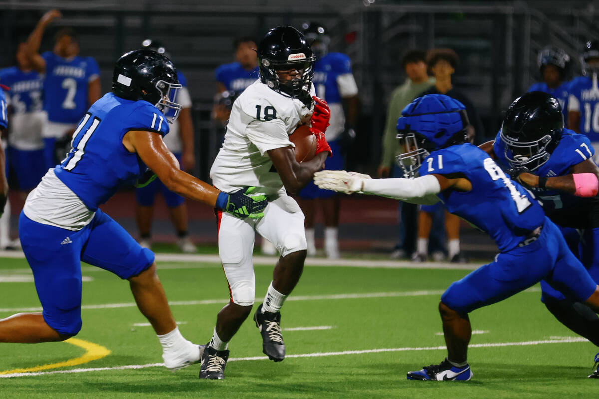 Las Vegas’ Jakhai Jones (18) tries to evade tackles from Desert Pines players during a f ...