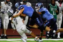 Palo Verde quarterback Kobe Arinwine (7) is taken down by Centennial defensive end Bailey Hucal ...