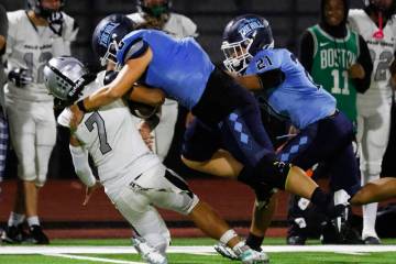 Palo Verde quarterback Kobe Arinwine (7) is taken down by Centennial defensive end Bailey Hucal ...
