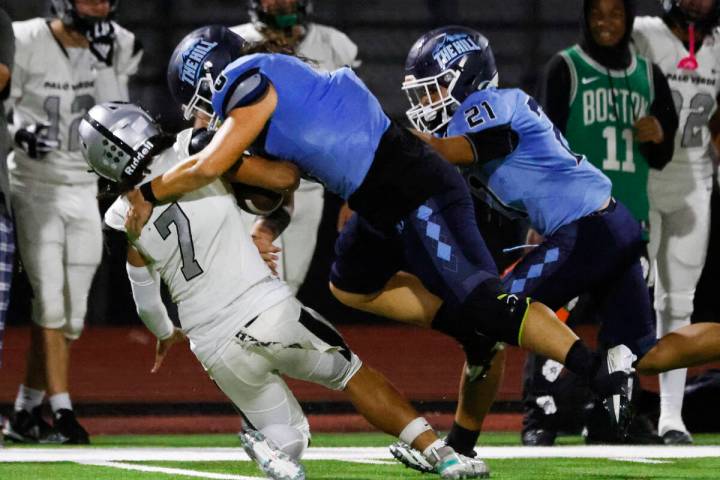 Palo Verde quarterback Kobe Arinwine (7) is taken down by Centennial defensive end Bailey Hucal ...