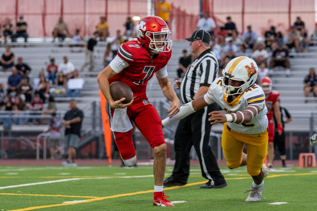 Arbor View Quarterback Thaddeus Thatcher (7) navigates through defenders during a football game ...
