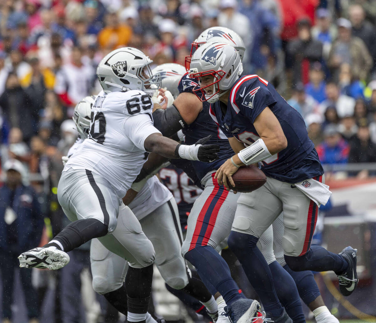 Raiders defensive tackle Adam Butler (69) attempts to knock the football loose from New England ...