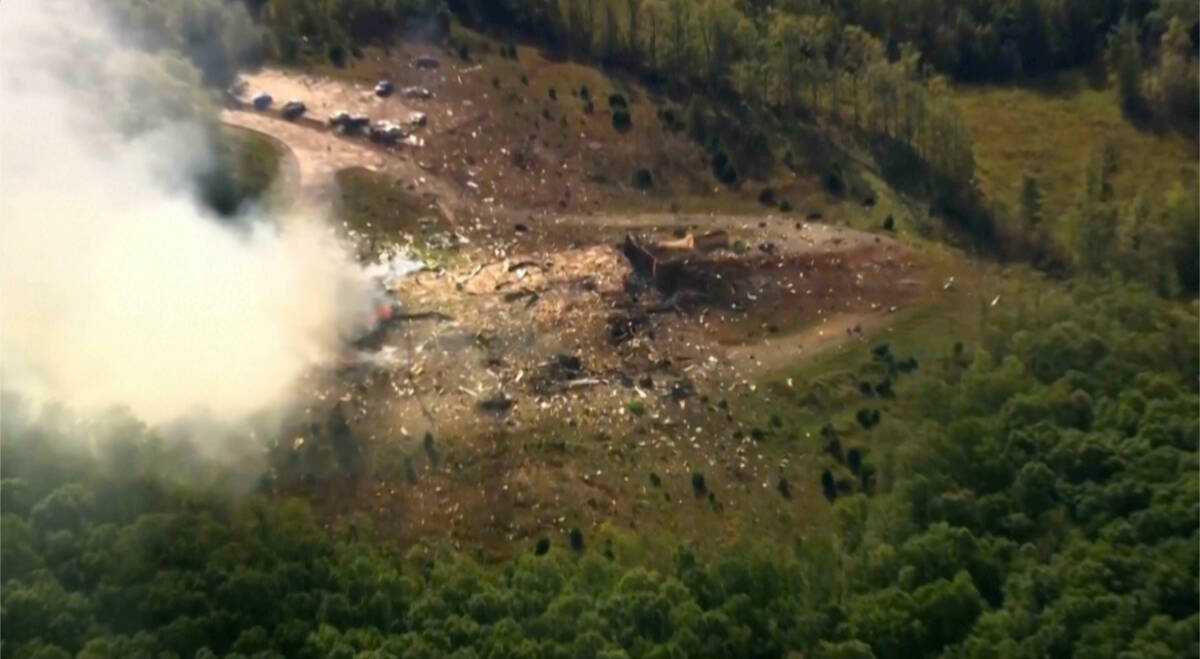 Smoke fills the air as debris covers the ground and vehicles after a powerful blast ripped thro ...