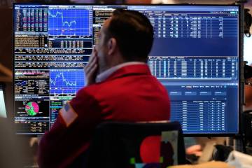 A trader looks at financial information on his computer on the floor at the New York Stock Exch ...