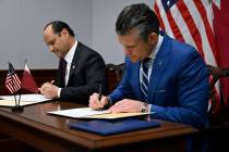 Qatari Defense Minister Sheikh Saoud Al Thani, left, signs an agreement with Secretary of War P ...