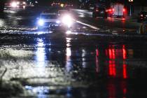 Cars travel through flood water on McLeod Drive near Desert Inn Road Friday, October 10, 2025, ...