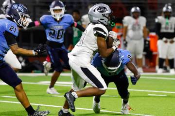 Palo Verde running back Rio Pascal (20) is tackled by Centennial safety Maxwell Miles (8) durin ...