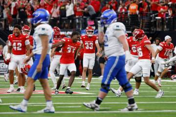 UNLV players celebrate their 51-48 win as Air Force Falcons players walk off the field during t ...