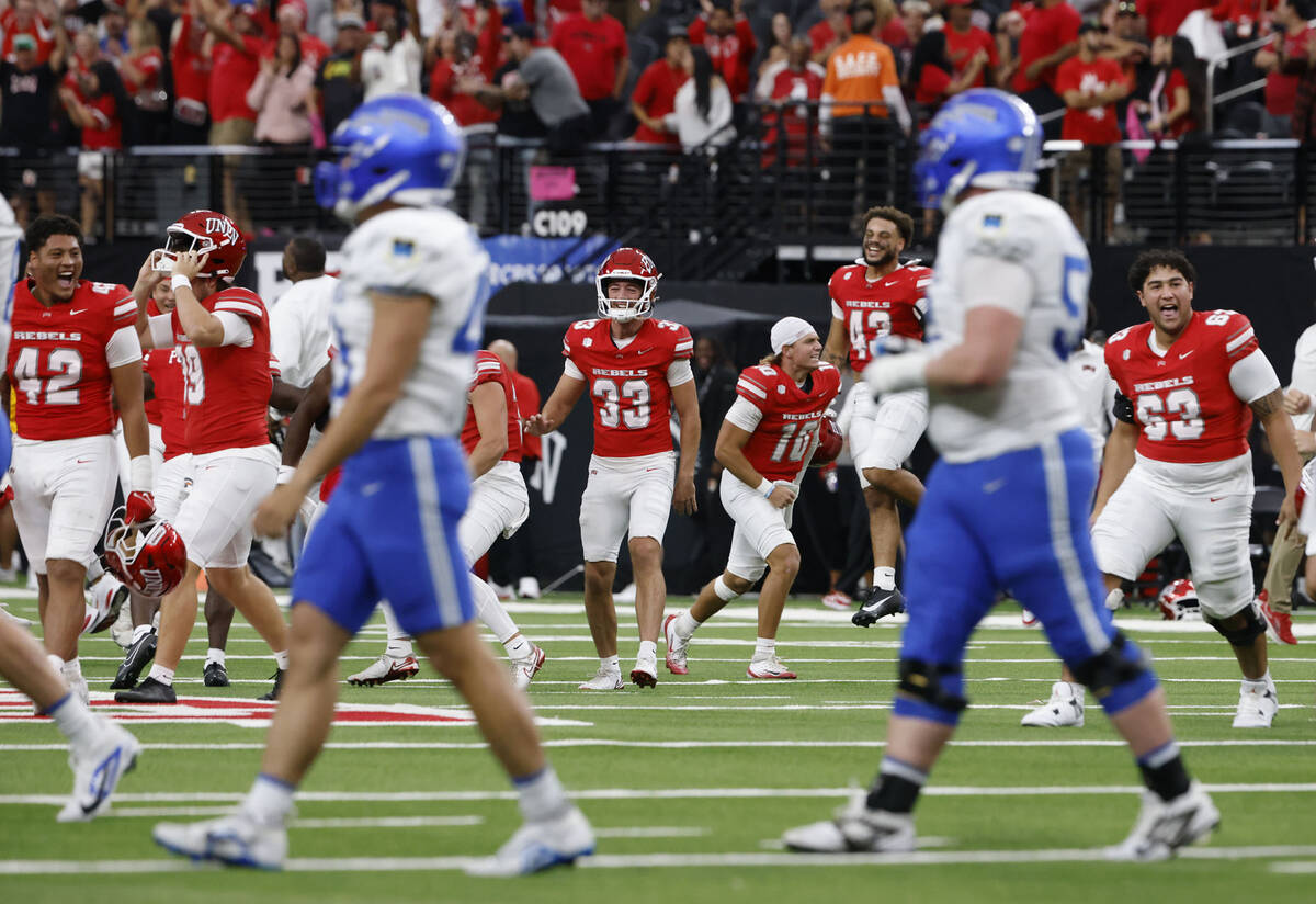 UNLV players celebrate their 51-48 win as Air Force Falcons players walk off the field during t ...