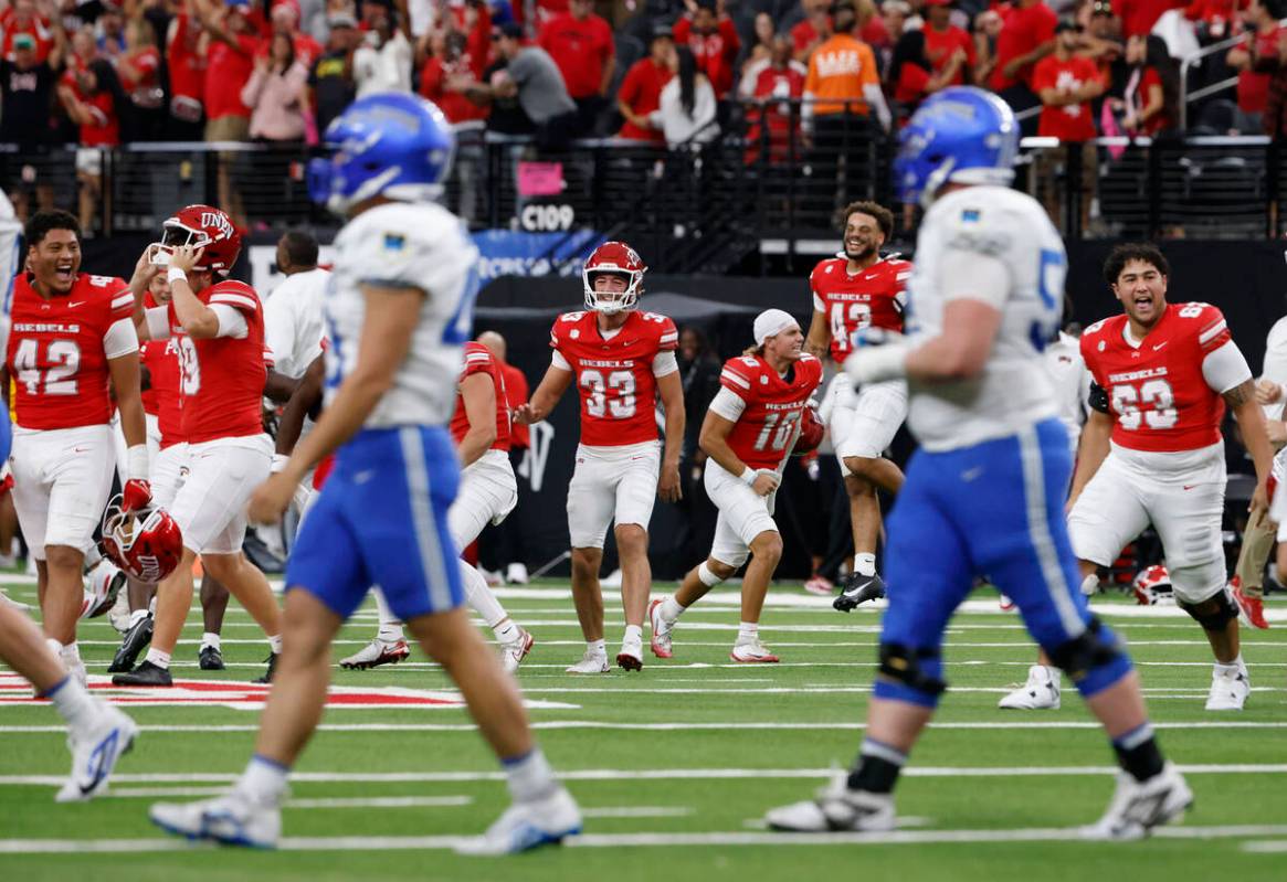 UNLV players celebrate their 51-48 win as Air Force Falcons players walk off the field during t ...