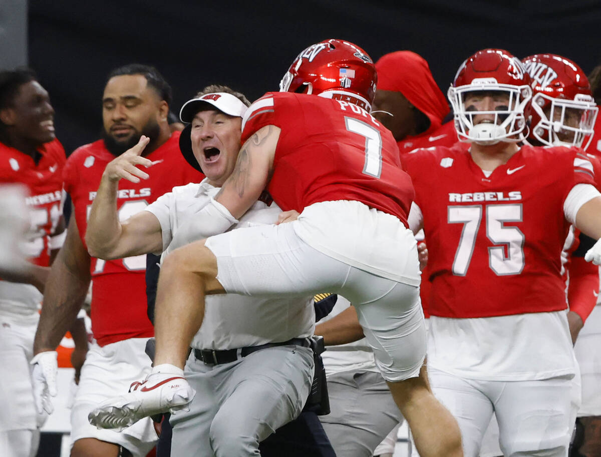 UNLV head coach Daniel Mullen celebrates his team 51-48 win with defensive back Jake Pope (7) d ...