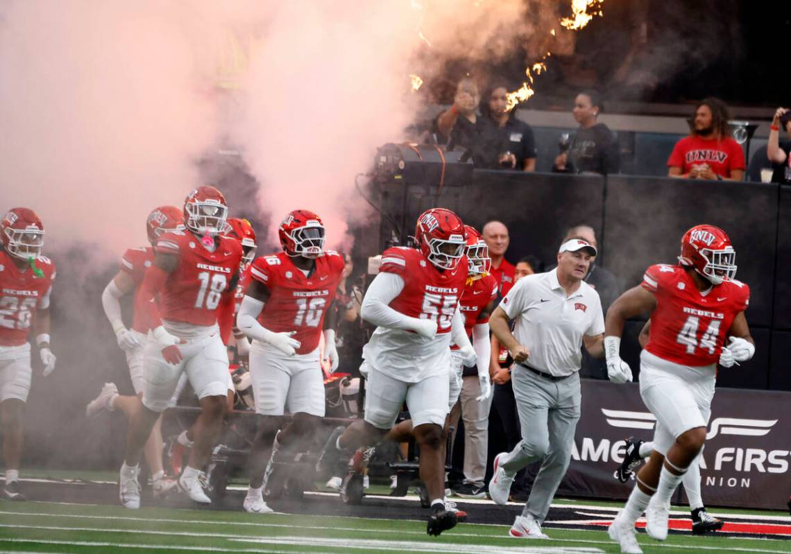 UNLV head coach Daniel Mullen, second right, and his players take the field to face Air Force F ...