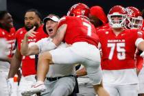UNLV head coach Daniel Mullen celebrates his team 51-48 win with defensive back Jake Pope (7) d ...
