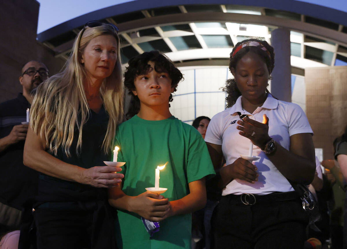 Leann Kramer, left, her son Kineau, 12, and Annet Sorongi, right, attend a prayer vigil for Hay ...
